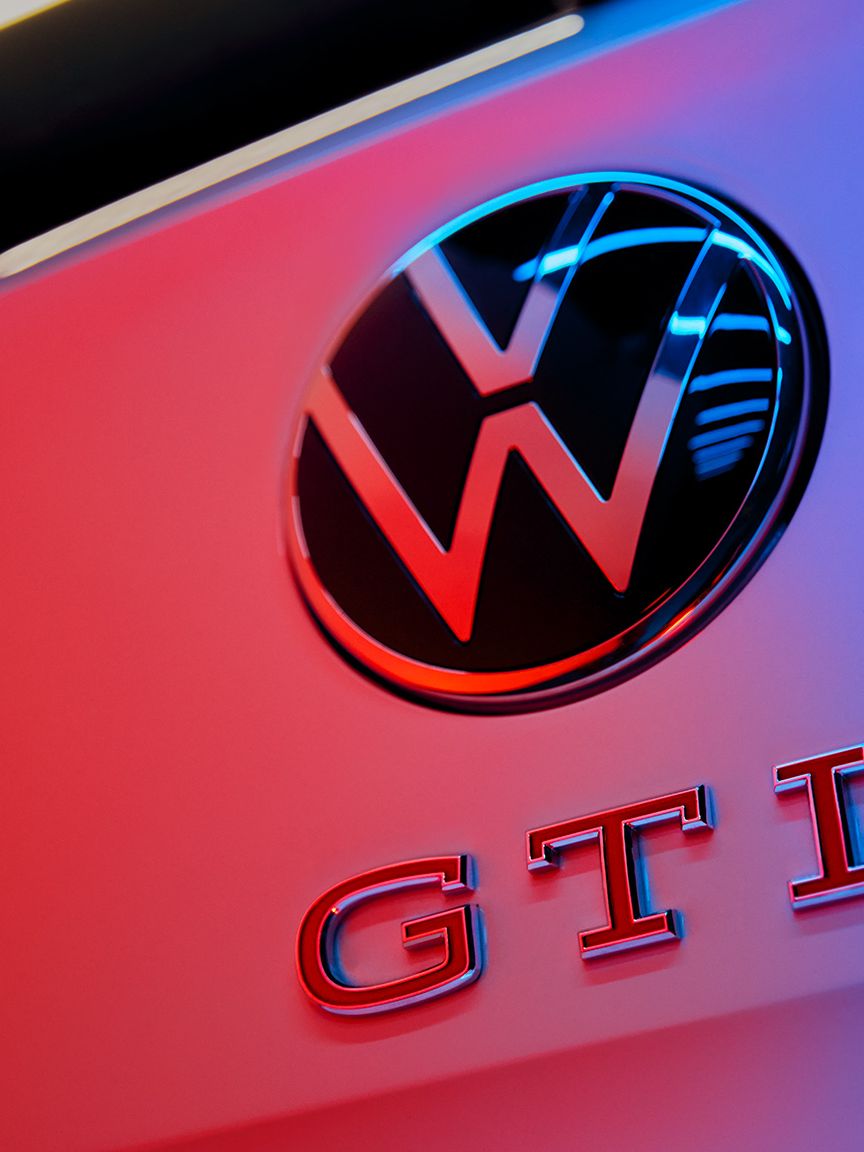 Detailaufnahme des VW-Logos und des GTI-Badge mit roten Buchstaben am Heck des Polo GTI.