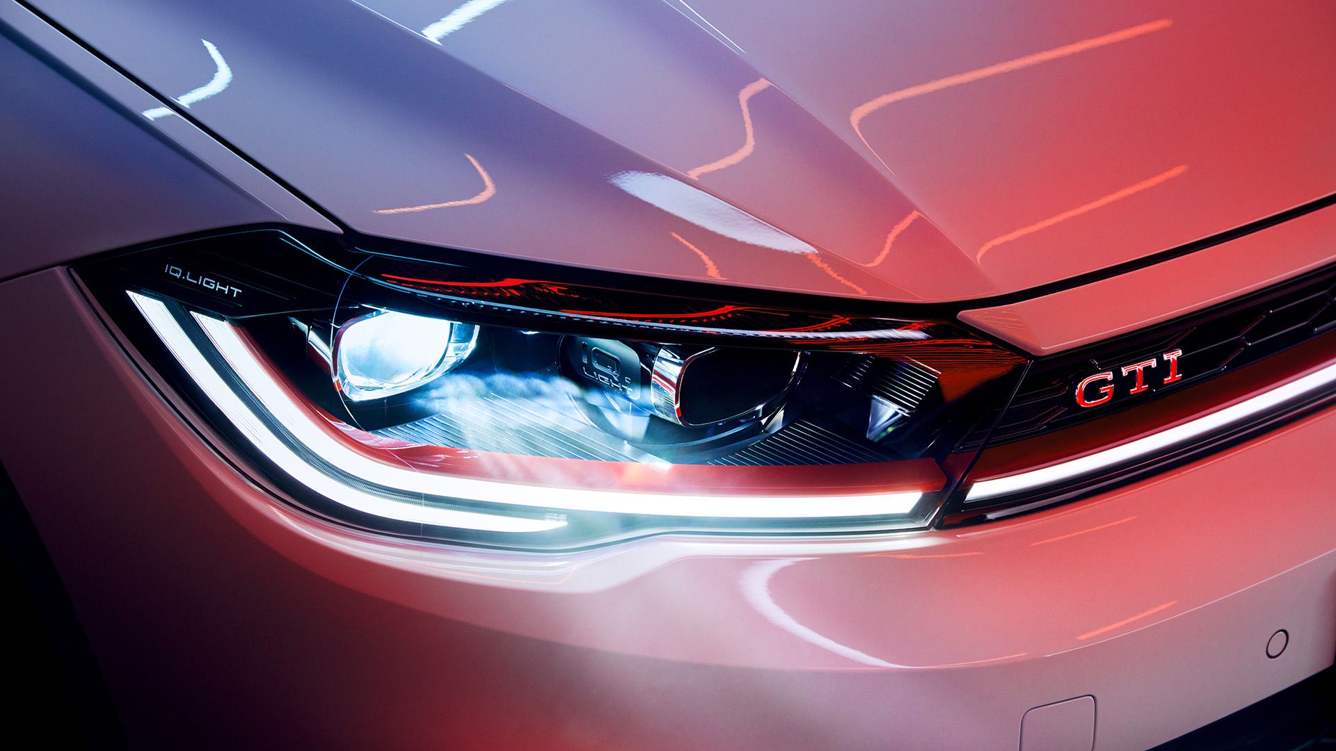 Detailaufnahme der LED-Matrix-Scheinwerfer in der Front eines VW Polo GTI in Weiß, roter Zierstreifen und GTI-Badge erkennbar.